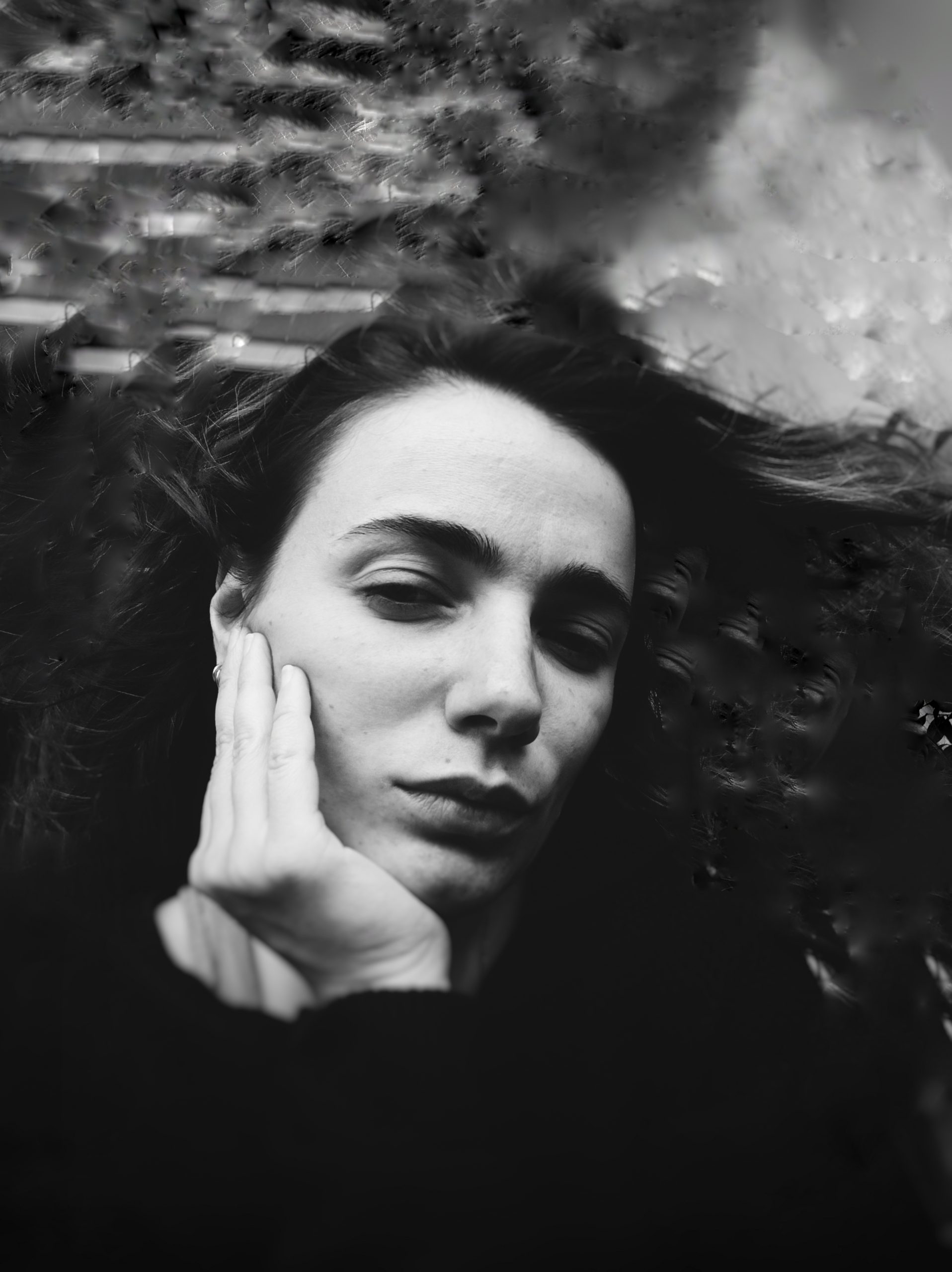 Portrait of Diana Kroshilova, an ultra-contemporary artist, sitting in her studio.